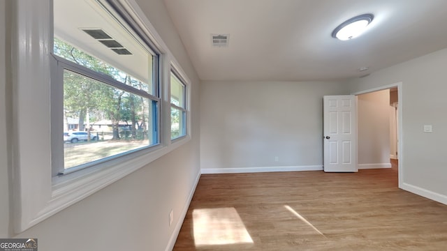 spare room with light hardwood / wood-style floors and a wealth of natural light