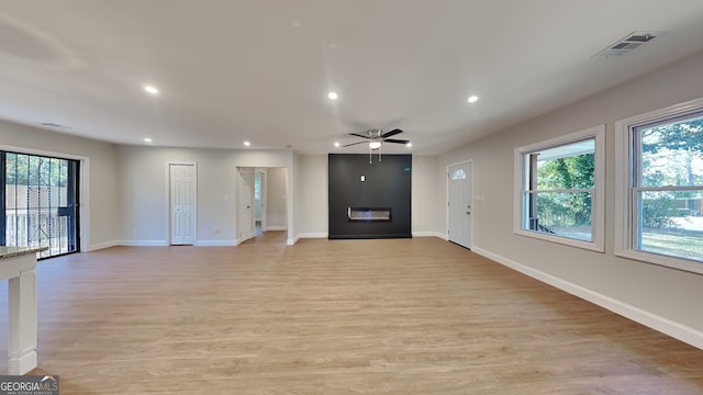 unfurnished living room featuring ceiling fan and light hardwood / wood-style floors