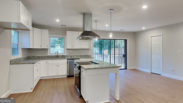 kitchen featuring island exhaust hood, electric range, white cabinets, and a healthy amount of sunlight