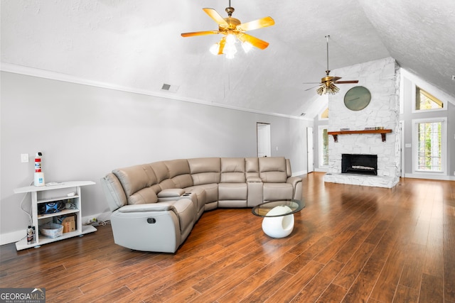 living room featuring a textured ceiling, lofted ceiling, hardwood / wood-style flooring, a fireplace, and ornamental molding