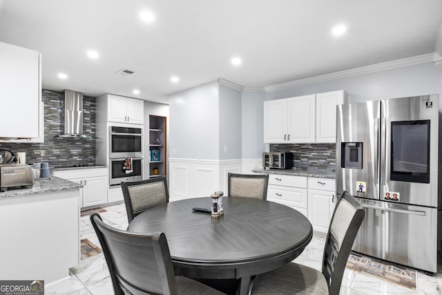 kitchen featuring white cabinets, wall chimney exhaust hood, light stone counters, and appliances with stainless steel finishes