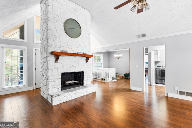 living room featuring plenty of natural light, a fireplace, wood-type flooring, and a textured ceiling