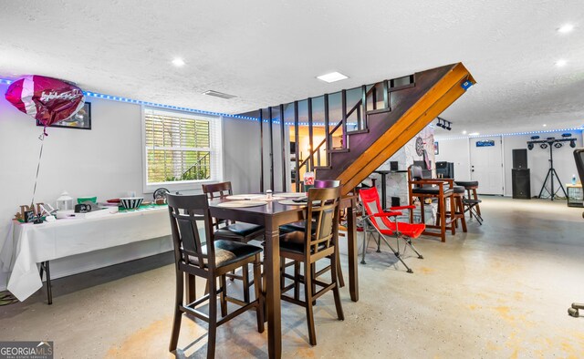 dining space with a textured ceiling and concrete floors