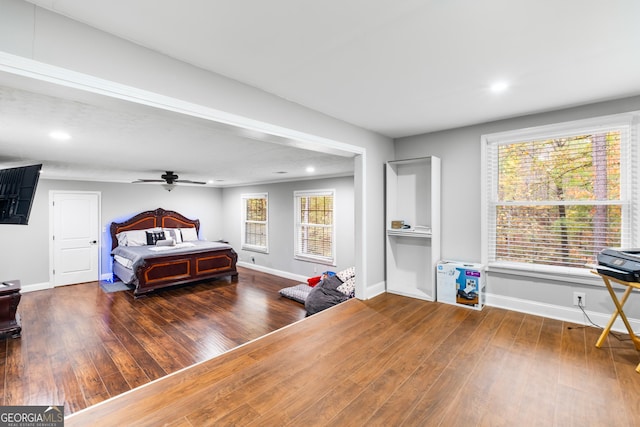 bedroom with multiple windows and dark hardwood / wood-style flooring