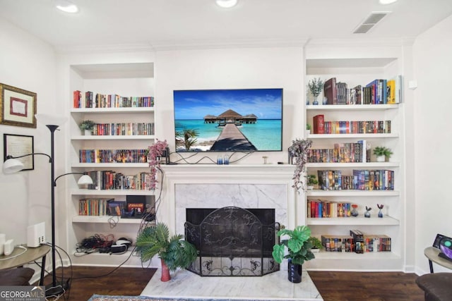 living room featuring built in shelves and dark hardwood / wood-style floors