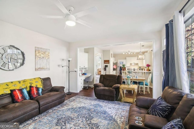 living room featuring ceiling fan and dark wood-type flooring