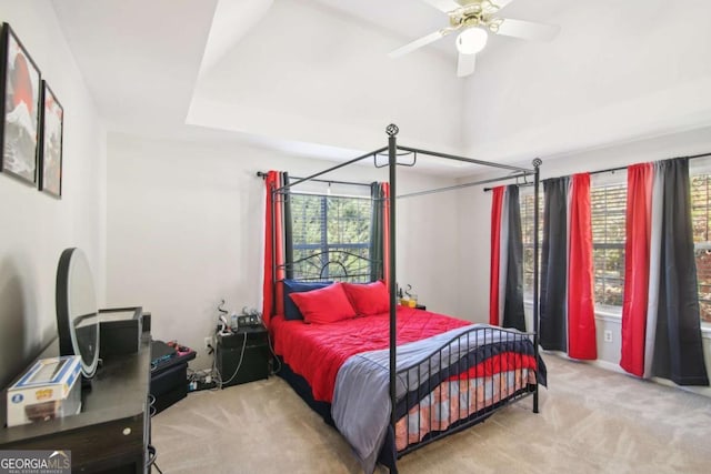 carpeted bedroom with multiple windows and ceiling fan