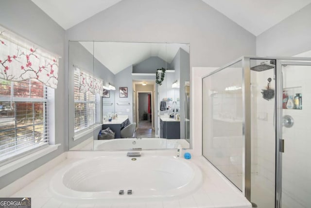 bathroom featuring plus walk in shower, vanity, and vaulted ceiling