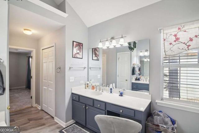 bathroom with vanity, wood-type flooring, and lofted ceiling