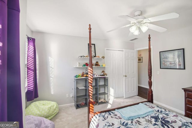 bedroom with ceiling fan, light carpet, and a closet