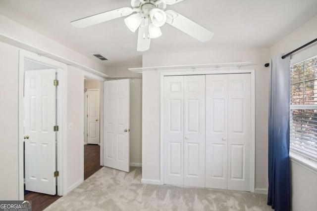 unfurnished bedroom with ceiling fan, a closet, and light colored carpet