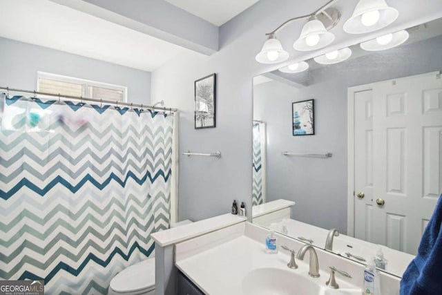 bathroom with vanity, curtained shower, and toilet