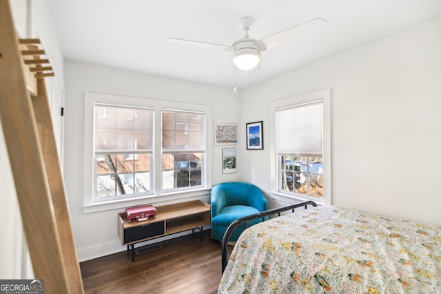 bedroom featuring dark hardwood / wood-style floors, multiple windows, and ceiling fan