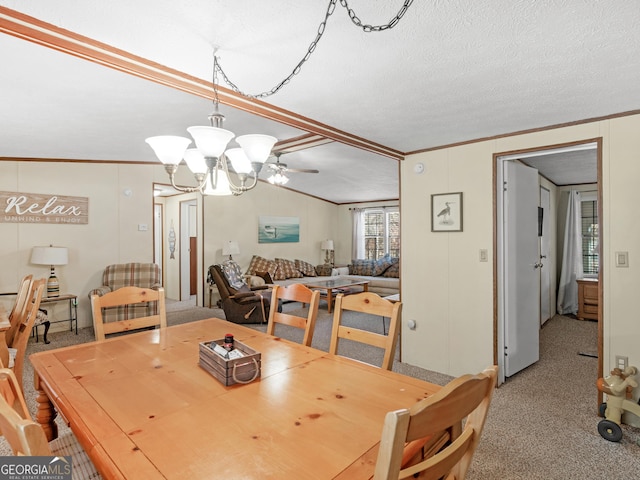 carpeted dining room featuring ceiling fan with notable chandelier, a textured ceiling, vaulted ceiling, and ornamental molding