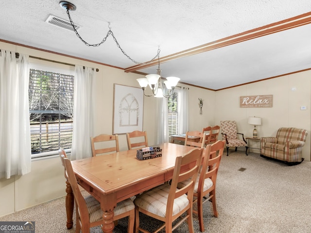 dining area with light carpet, ornamental molding, a textured ceiling, and an inviting chandelier