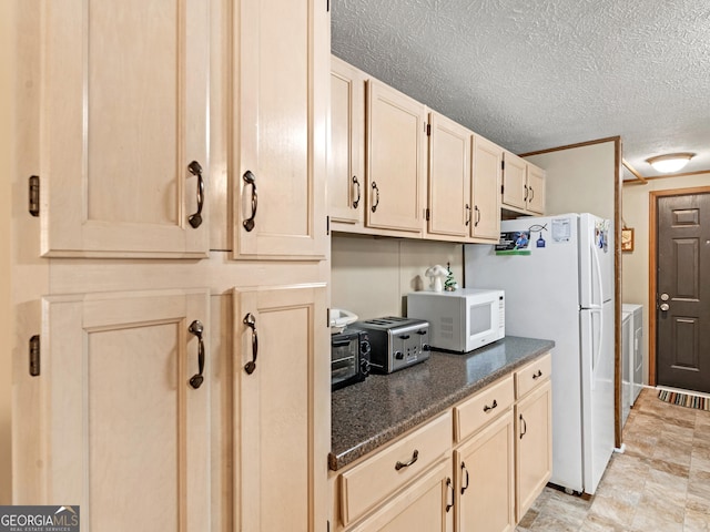 kitchen featuring a textured ceiling, white appliances, and washer / dryer