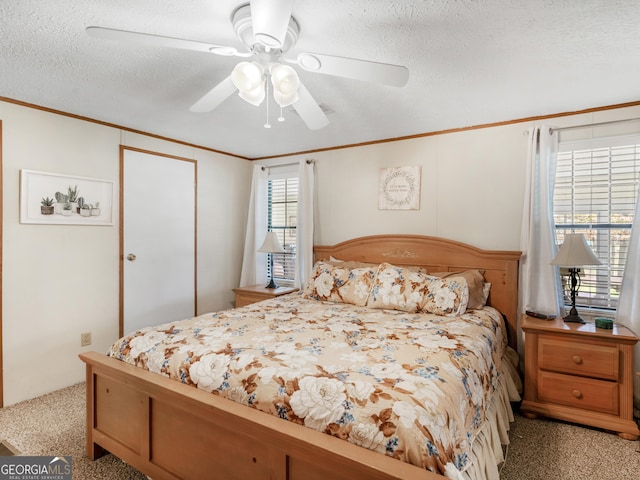 carpeted bedroom featuring ceiling fan, a closet, crown molding, and a textured ceiling