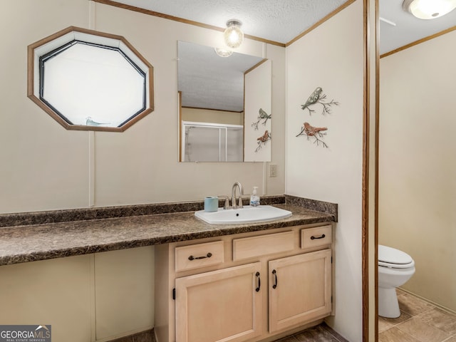 bathroom featuring walk in shower, a textured ceiling, toilet, vanity, and ornamental molding