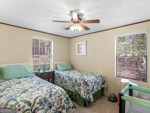 carpeted bedroom featuring ceiling fan, ornamental molding, and a textured ceiling