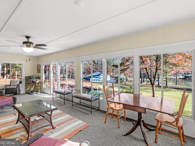 sunroom with a water view, plenty of natural light, and ceiling fan