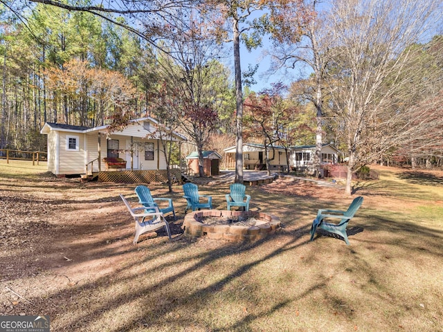 view of yard featuring a fire pit and an outbuilding