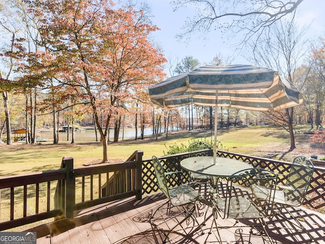 wooden deck with a yard and a water view