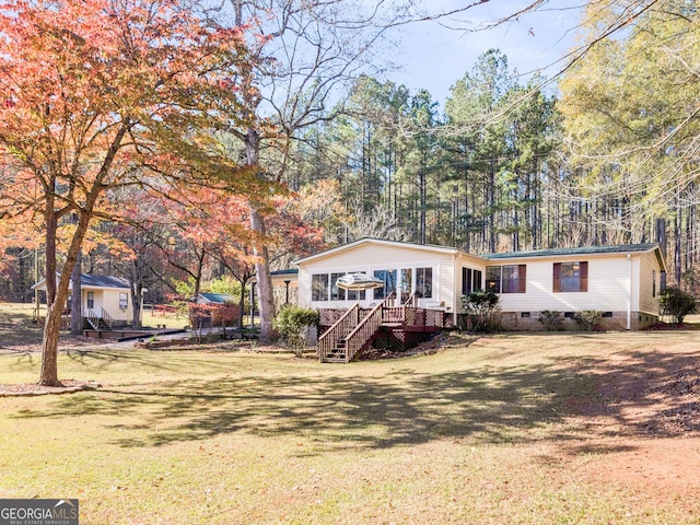 view of front of property with a front yard and a wooden deck