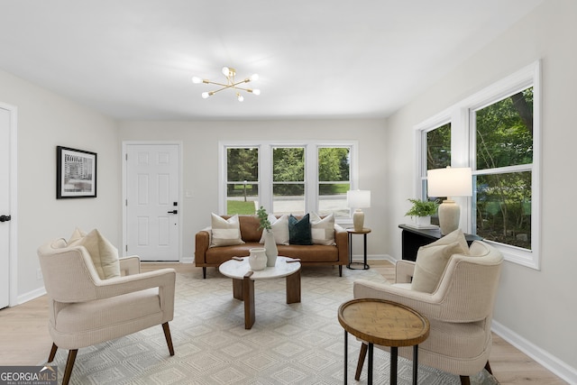 living room with a notable chandelier, a healthy amount of sunlight, and light hardwood / wood-style floors