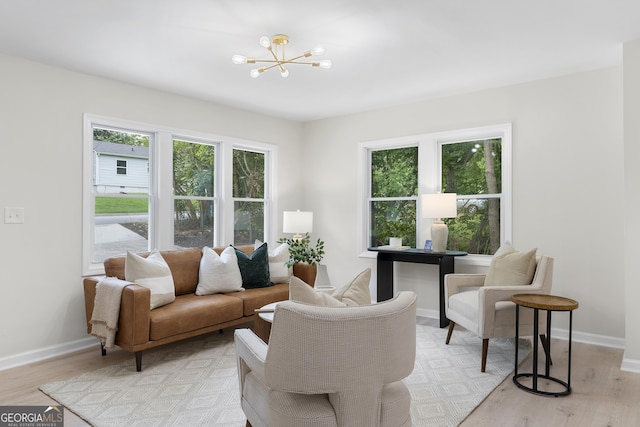 living room with light hardwood / wood-style flooring and an inviting chandelier