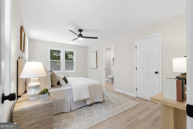 bedroom featuring light wood-type flooring, ensuite bath, and ceiling fan