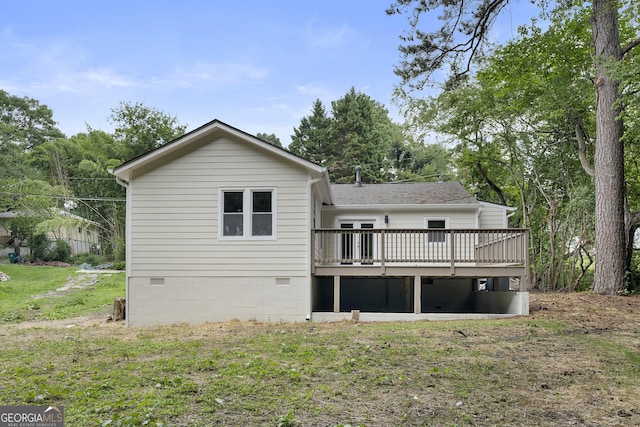 back of property with a deck and a lawn