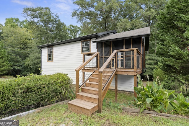 rear view of property with a sunroom