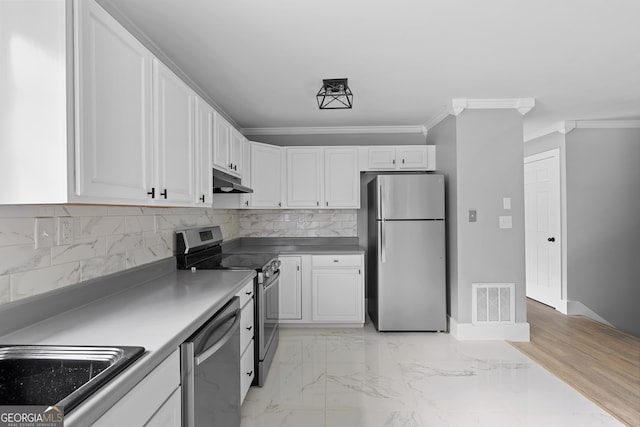 kitchen with white cabinets, stainless steel appliances, ornamental molding, and sink