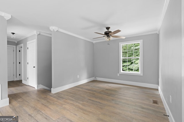 empty room featuring ornamental molding and hardwood / wood-style flooring