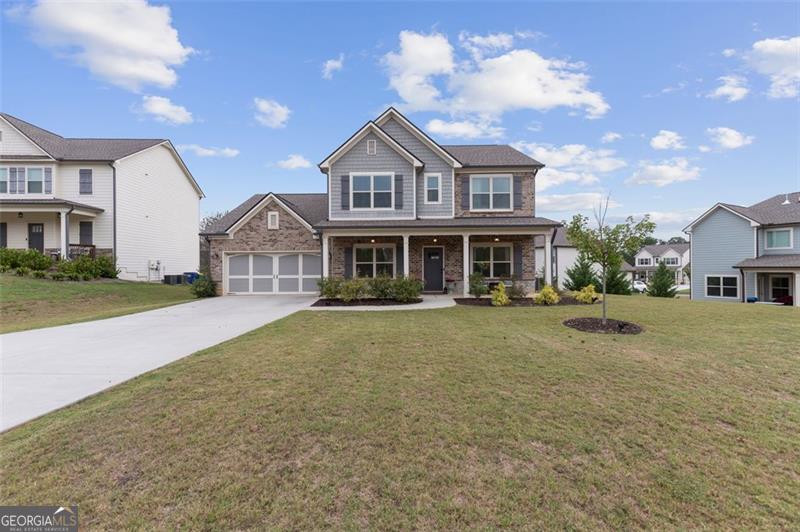 craftsman house with covered porch, a front yard, and a garage