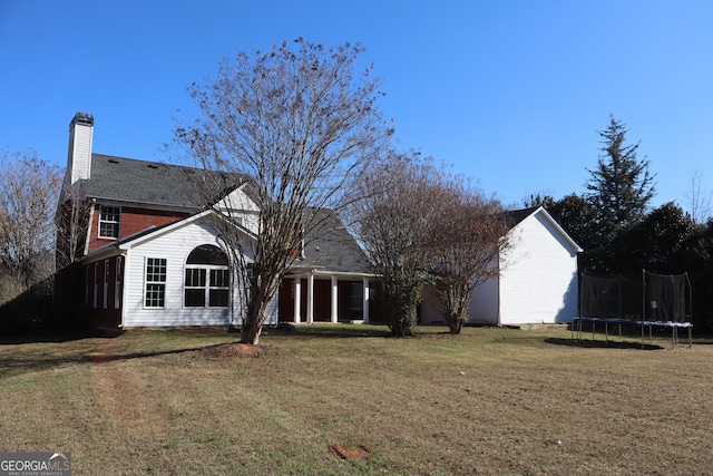 exterior space featuring a trampoline and a lawn