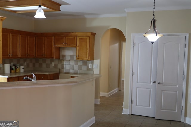 kitchen featuring decorative light fixtures, decorative backsplash, crown molding, and light tile patterned floors