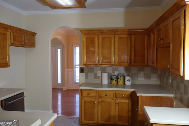 kitchen featuring decorative backsplash, dishwasher, crown molding, and light hardwood / wood-style flooring