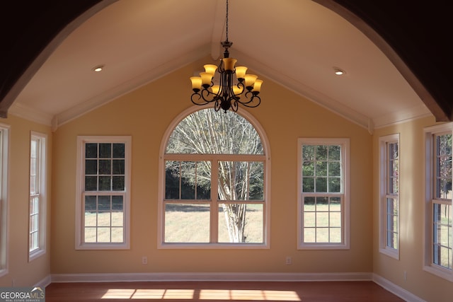 unfurnished sunroom featuring a notable chandelier, a wealth of natural light, and vaulted ceiling