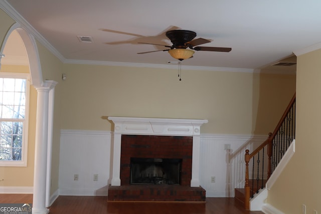 unfurnished living room featuring hardwood / wood-style flooring, ceiling fan, crown molding, and a fireplace