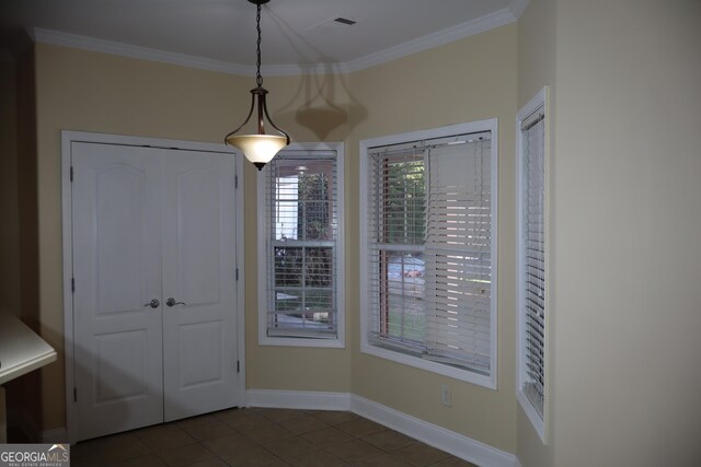 interior space featuring dark tile patterned flooring and ornamental molding