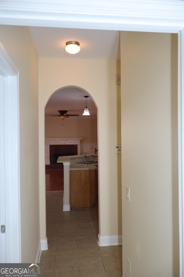 corridor with light tile patterned flooring and sink