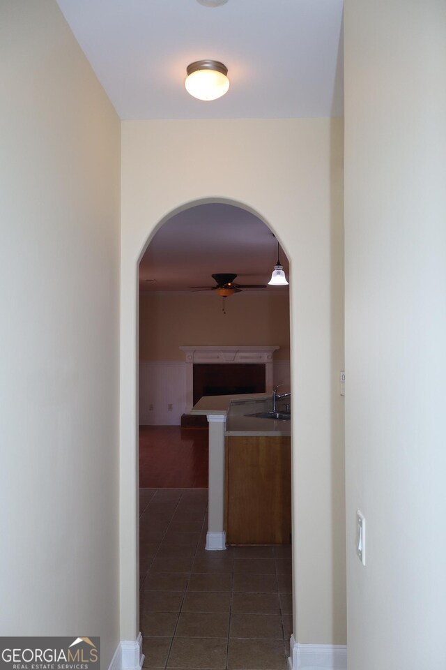 corridor with dark tile patterned floors and sink