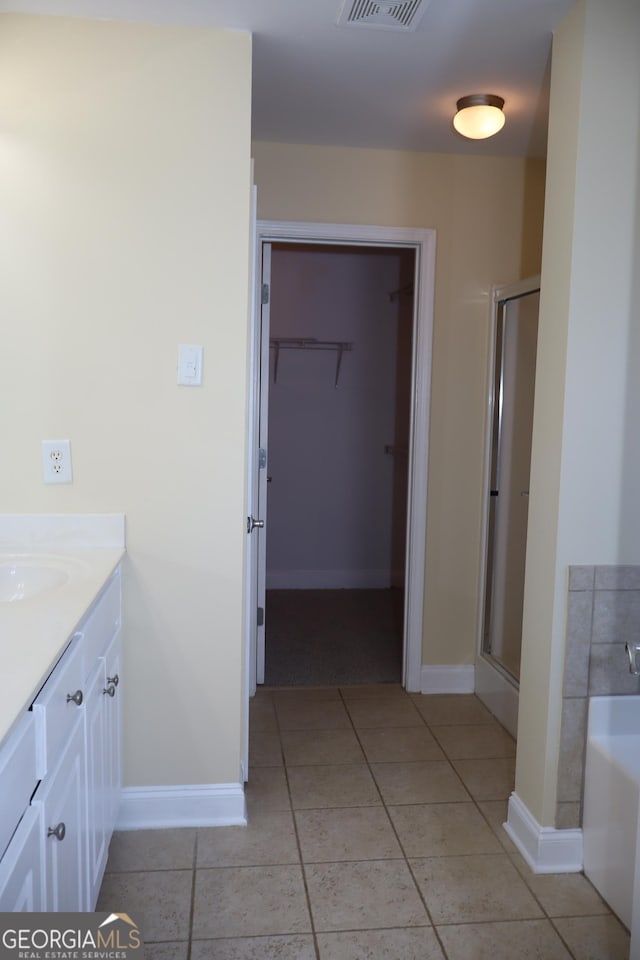 bathroom with tile patterned floors, vanity, and plus walk in shower