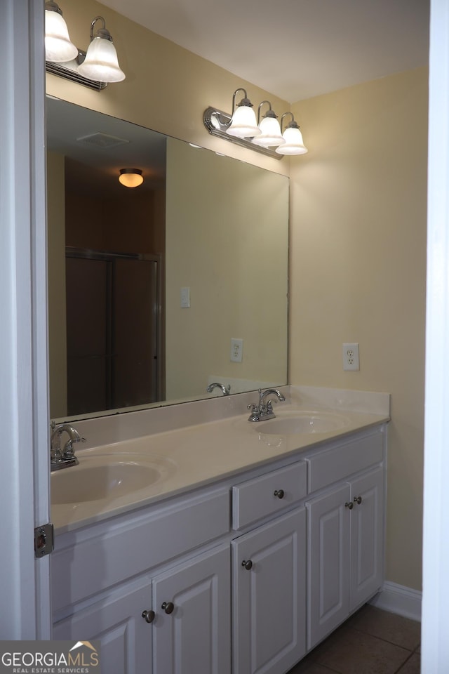 bathroom with tile patterned flooring, vanity, and walk in shower