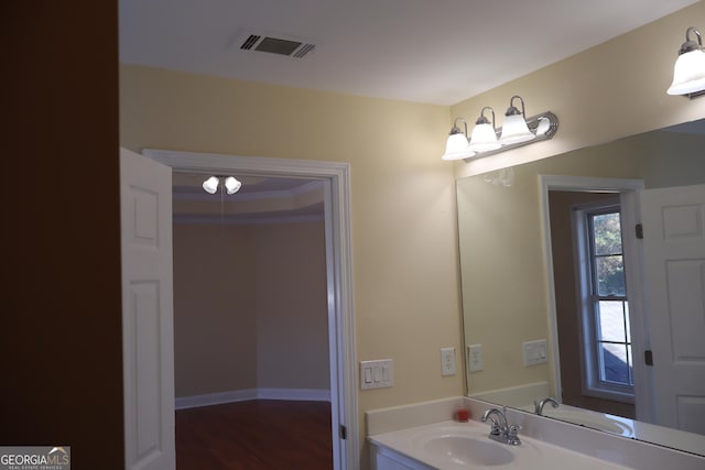 bathroom with wood-type flooring, vanity, and ornamental molding