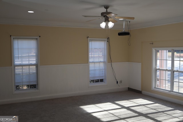 empty room with carpet flooring, ceiling fan, and crown molding