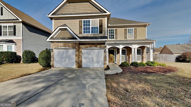 view of front of house featuring covered porch, a garage, and a front yard