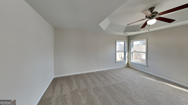 unfurnished room with light colored carpet, ceiling fan, and a tray ceiling