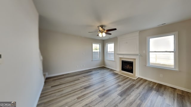 unfurnished living room with ceiling fan and light hardwood / wood-style flooring